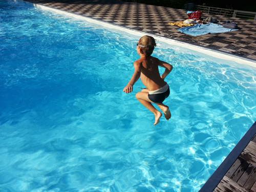 barn som hoppar ner i en pool